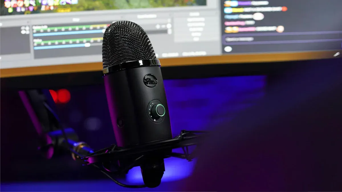 A black Blue Yeti X microphone on a boom arm in front of a streaming setup
