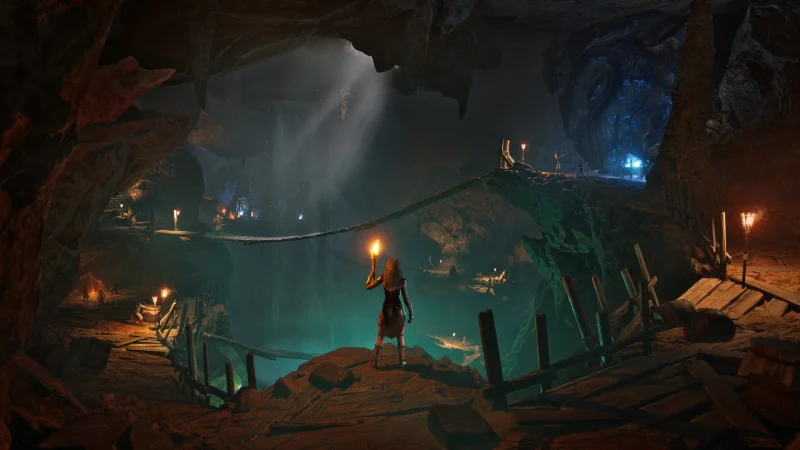 A torch-carrying explorer looks over a vast cave with rope bridges and wooden walkways in Conan Exiles Enhanced