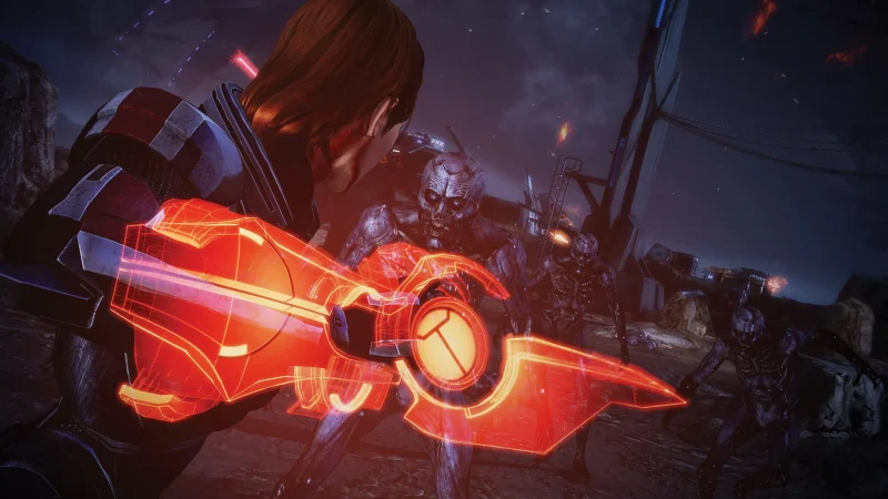 Commander Shepard strikes an enemy with a glowing orange omni-blade in Mass Effect Legendary Edition