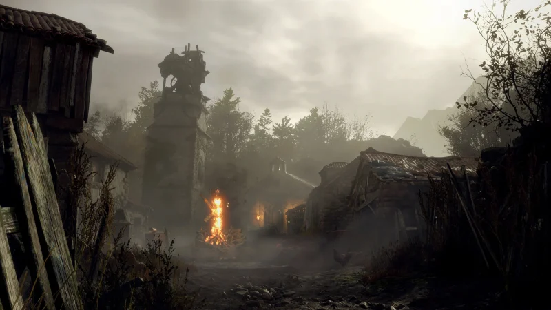 A burning village under a grey sky in Resident Evil 4