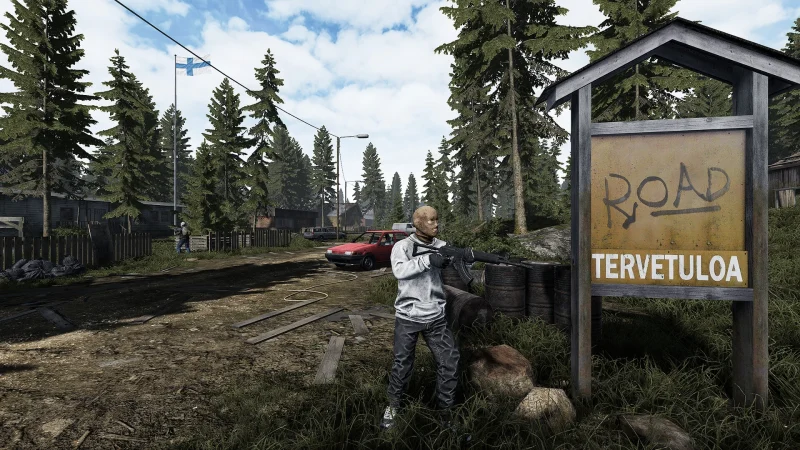A survivor stands by a road sign in a Finnish forest town in Road to Vostok