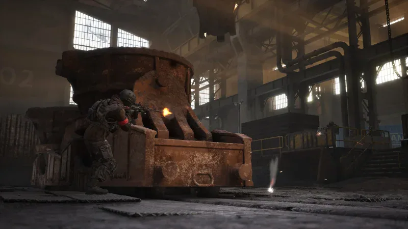 A soldier takes cover behind a rusted machine inside a factory hall in WARDOGS