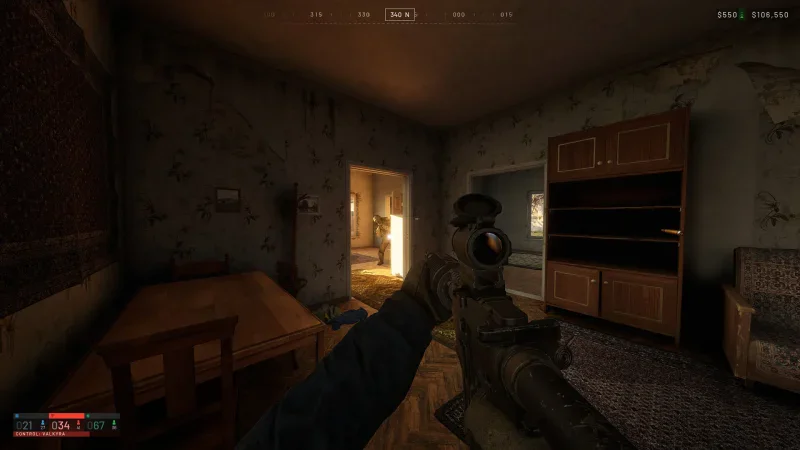 A first-person view of a rifle aimed at a smoking apartment block beside a freight train in WARDOGS